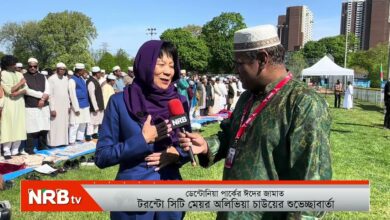 Woman in a blue suit being interviewed by a reporter holding a red microphone with NRB TV logo at a prayer gathering outdoors. Line of people in traditional dress behind them.