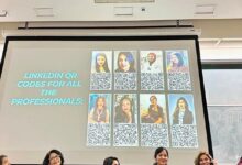 Panel of seven women seated on a stage while a projector screen shows a slide reading 'LinkedIn QR codes for all the professionals' with headshots and QR codes in a grid.