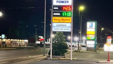 Tall illuminated Pioneer gas station sign at night showing fuel prices and banners for Hasty Market and U-Haul.