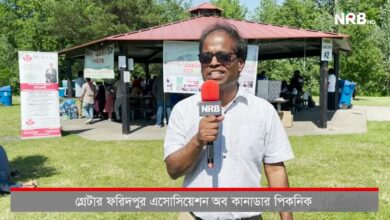 Reporter wearing sunglasses speaks into an NRB microphone at an outdoor park event under a red-roof pavilion, with banners and attendees in the background (NRB HD logo visible).