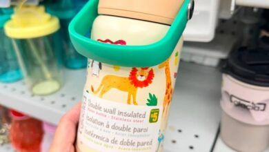 Kid's double-wall insulated bottle with teal flip lid, featuring colorful animal print, held in a store aisle