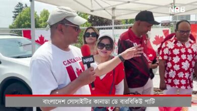 Man wearing a light cap speaks into a red NRB microphone under a white canopy while others in red stand nearby, Canada flags in the background.