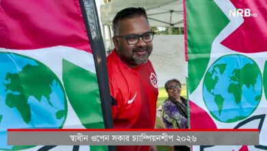 Smiling man in a red jacket with glasses stands beside colorful banners showing Earth globes at a public event; NRB HD watermark in corner.